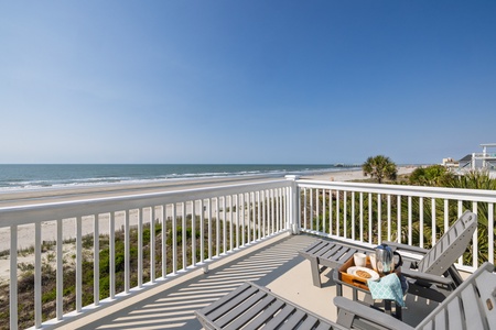 Oceanfront balcony offers stunning beach and ocean views with comfortable seating for morning coffee or sunset relaxation.