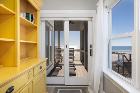 Your sunny yellow shelving adds cheerful charm while ocean views stretch endlessly beyond your private balcony.