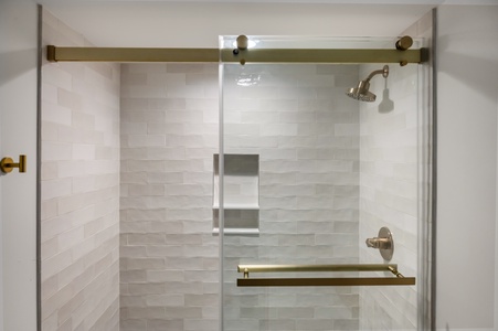 Step into your sleek glass-enclosed shower with elegant subway tile walls and brushed gold fixtures for a luxurious daily refresh.