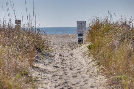Sandy pathway through the coastal dunes leads directly to pristine beach