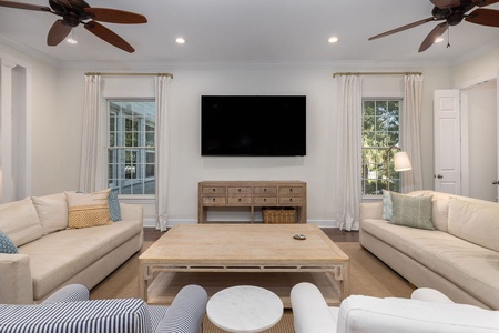Your spacious open-concept living area features plush seating and ceiling fans.