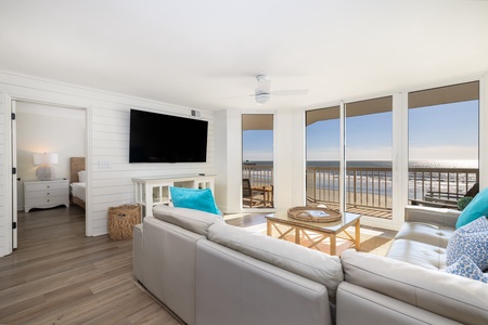 Unwind in your bright oceanfront living room with plush seating and stunning beach views through floor-to-ceiling windows.