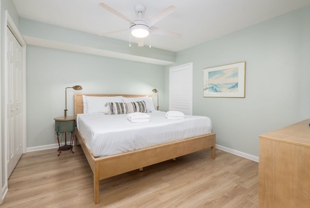Drift off to peaceful sleep in this soothing bedroom with soft mint walls, crisp white linens, and gentle coastal artwork creating your perfect retreat.