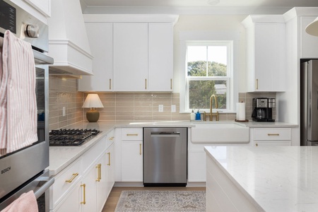 Your bright, fully-equipped kitchen awaits with gleaming quartz counters, stainless appliances, and everything needed for memorable meals together.