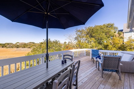 Unwind on your private deck with stunning marsh views, complete with dining table and comfortable seating under the shade umbrella.