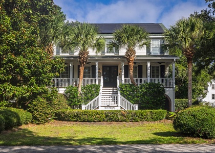Southern charm welcomes you home – a classic Lowcountry front porch framed by palms