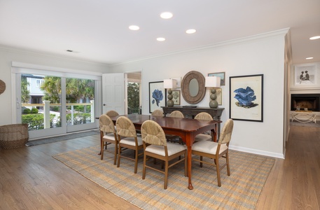 Gather around this elegant dining table where memorable meals unfold, surrounded by coastal charm and natural light streaming through garden views.