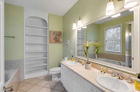 Refresh yourself in this bright bathroom featuring dual sinks, built-in storage, and elegant lighting for your morning routine.