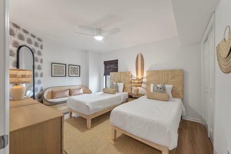 Unwind in your coastal-inspired bedroom featuring twin beds with woven headboards, natural textures, and thoughtful decor that brings beachside serenity indoors.