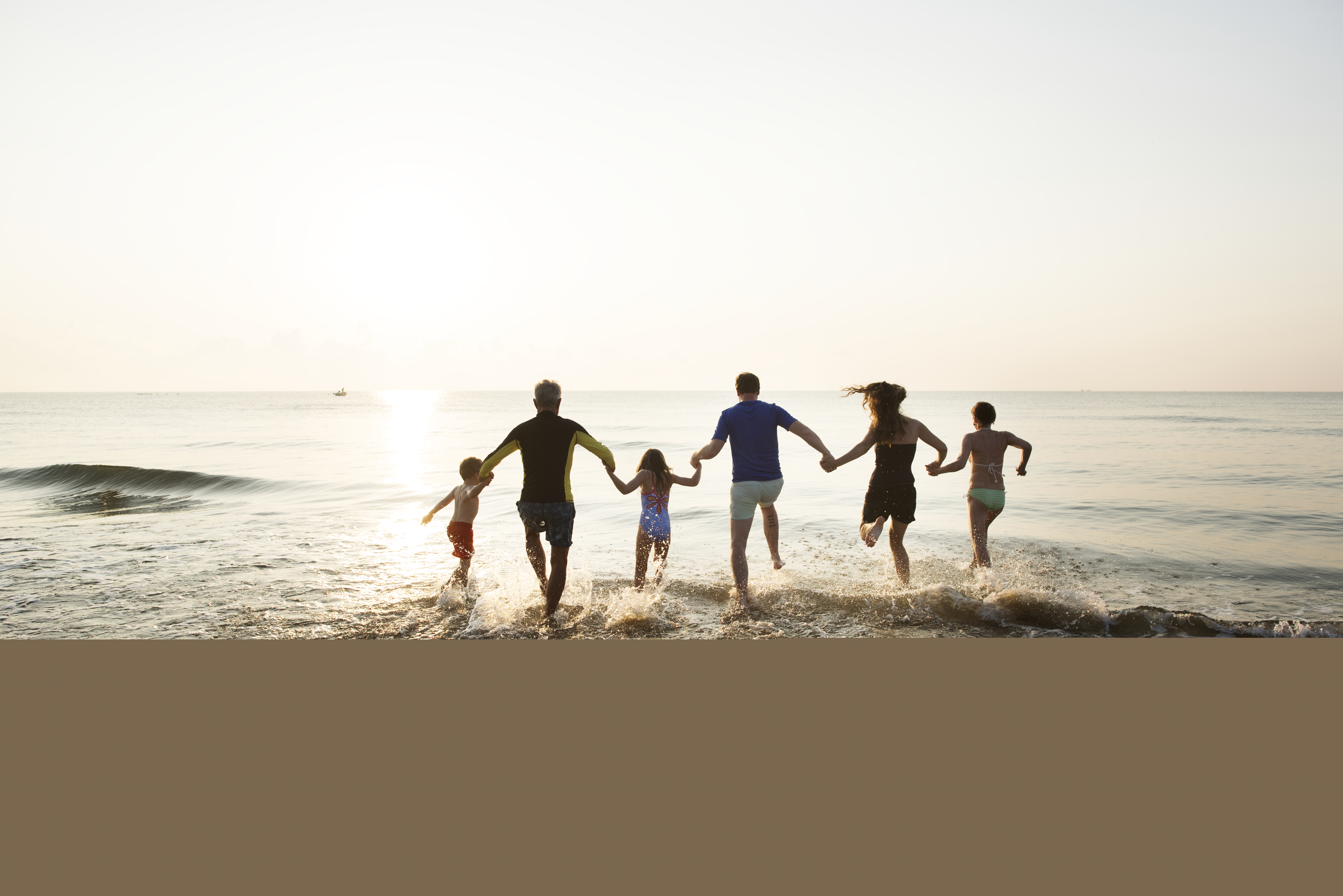 family-playing-at-the-beach-KDFCJLG