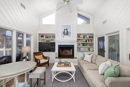 Unwind in your bright living space with soaring ceilings, cozy fireplace, and built-in shelves perfect for evening relaxation.