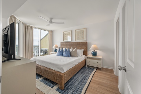 Your coastal bedroom retreat features a woven headboard, soft blue accents, and warm bedside lighting for peaceful evenings after exploring the waterfront.