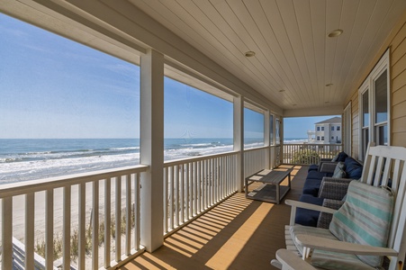 Relax on your covered beachfront porch with stunning ocean views and comfortable seating perfect for morning coffee or sunset cocktails.