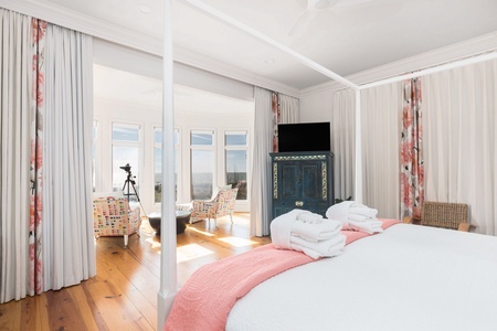 Wake up to sweeping views and sunlight streaming through tall windows in your primary bedroom