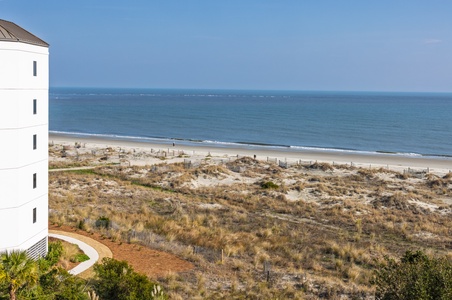 Beachfront property overlooks pristine coastline with direct access to sandy shores and ocean waves.