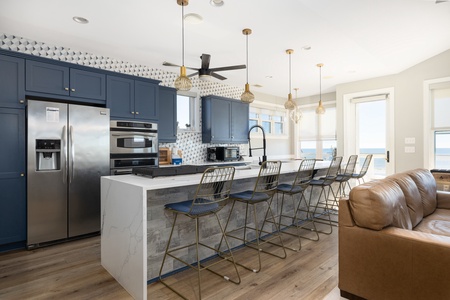 Your spacious open-concept kitchen welcomes you with sleek navy cabinetry and modern appliances