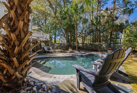 Sink into comfortable Adirondack chairs around your private pool, surrounded by lush tropical landscaping and mature trees that create perfect poolside shade.