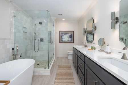 The primary en suite bathroom features a large soaking tub, glass walk-in shower, and dual vanities