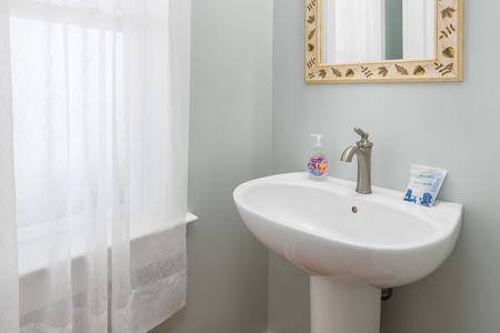 Refresh in this pristine bathroom with elegant sage walls, coastal touches, and thoughtful amenities waiting for your arrival.