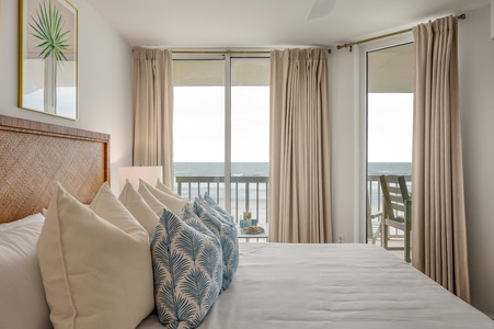 Wake up to endless ocean views from your serene bedroom, where tropical-inspired linens and a private balcony create your perfect seaside retreat.
