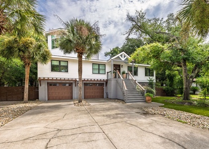 Charming coastal home with spacious driveway and lush palm trees — the perfect Isle of Palms vacation rental retreat