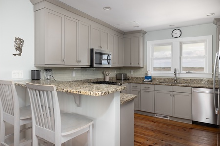 Your fully equipped kitchen features granite counters, stainless appliances, and a breakfast bar perfect for morning coffee or casual dining.
