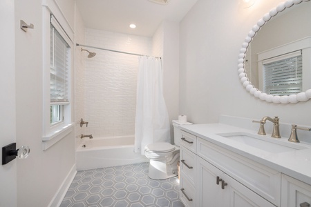 The two full bedroom en suite bathroom features these beautiful hexagonal tiles and circle mirror