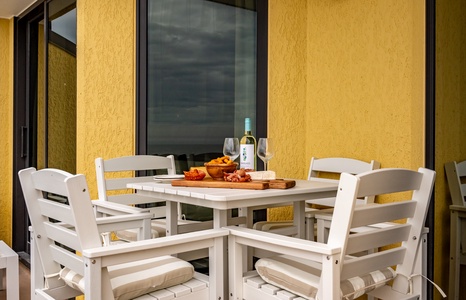 Savor local wine and cheese on your private terrace as golden evening light warms this intimate dining space.