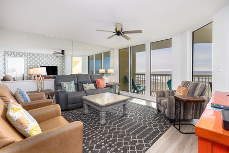 Relax and unwind in the bright, open-concept living space at Sand Fort FB 106 — floor-to-ceiling windows frame the ocean for a true coastal vibe.