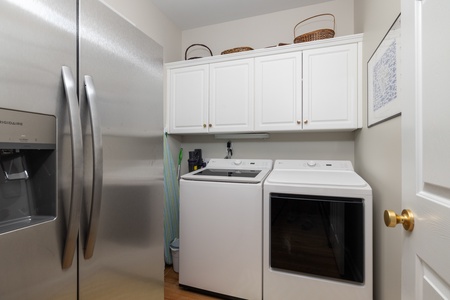 Beyond the kitchen is your laundry room, equipped with a second fridge