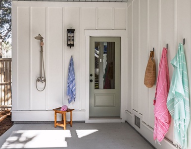 Step into your serene outdoor shower space, where colorful towels await and warm sunlight filters through for a refreshing start to your day.