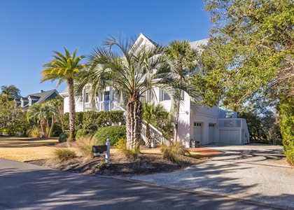 This charming coastal home is surrounded by swaying palms and lush tropical landscaping.