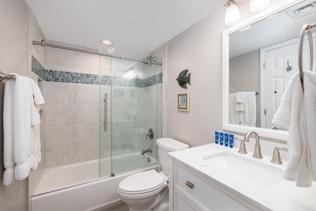 The twin bedroom en suite bathroom features a tub-shower combo and large vanity