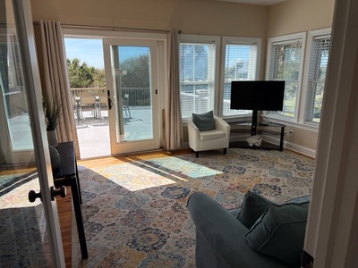 Your spacious living room opens to a private balcony through sliding glass doors, where natural light fills the comfortable seating area.