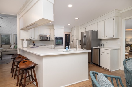 Your dream kitchen awaits with pristine white cabinets, spacious island, and premium stainless appliances - perfect for cooking memorable meals together.