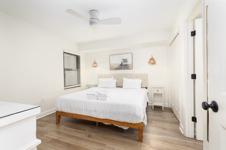 Drift into peaceful sleep in your bright, airy bedroom with crisp white linens and warm wood floors beneath your feet.