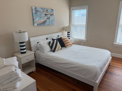 Drift off in your cozy nautical haven, complete with crisp linens, cheerful pillows, and gentle natural light streaming through the windows.