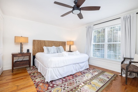 Inviting primary bedroom with king bed, natural light, and a calming coastal palette for a restful night’s sleep.