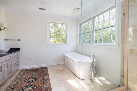 Large en suite primary bathroom with jack and jill sinks and a tub to unwind in.