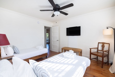 Spacious guest room with twin beds, smart TV, and charming Lowcountry details for a comfortable stay near the beach.