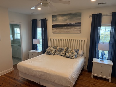 Drift off in your serene bedroom featuring coastal artwork, plush bedding, and warm lighting that creates the perfect sanctuary for rest.