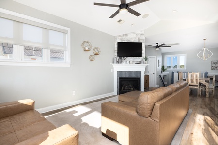 Sink into plush leather seating by your cozy fireplace, where natural light streams through large windows and ceiling fans keep you perfectly comfortable.