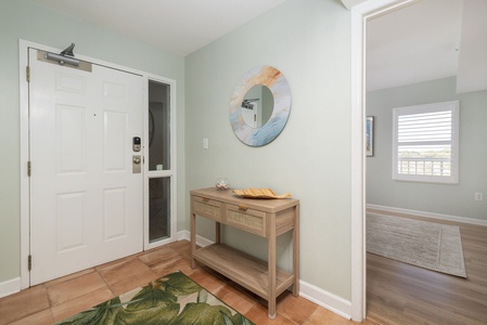 Step into your welcoming entryway with coastal charm, featuring soothing sage walls and warm wood accents that set the perfect tone for your beach retreat.