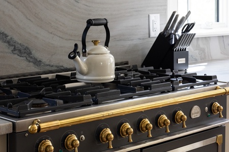 Whip up culinary masterpieces on this stunning professional-grade gas range with elegant brass fixtures and premium knife set.