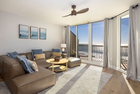 Sink into your comfortable sectional and enjoy stunning ocean views through floor-to-ceiling windows in this bright, coastal-inspired living space.