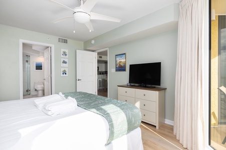Your serene bedroom offers crisp white linens, gentle ceiling fan breezes, and entertainment at your fingertips with the flat-screen TV.