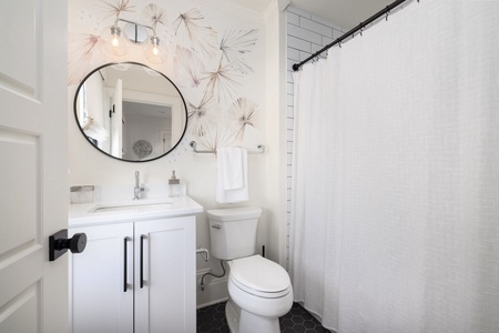 The en suite bathroom boasts a tub-shower combo and beautiful touches