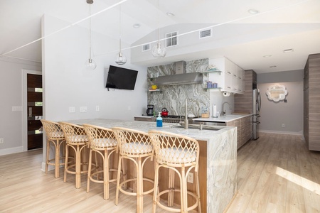 Bright, modern kitchen with quartz counters, stainless appliances, and island seating — designed for family gatherings and entertaining