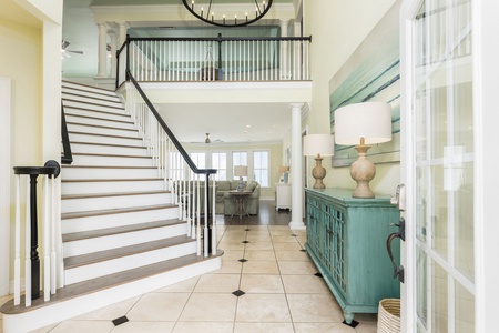 Your bright entryway features a wooden grand staircase