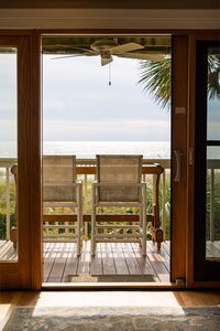 Your private balcony awaits with comfortable seating and stunning ocean views, where gentle sea breezes and tropical palms create the perfect retreat.